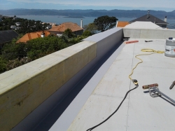 first sheet is in place, 2nd sheet in gutter is split due to higher parapet at this end