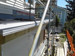 ledge on west side of back roof with TPO folded over and fastening bar installed